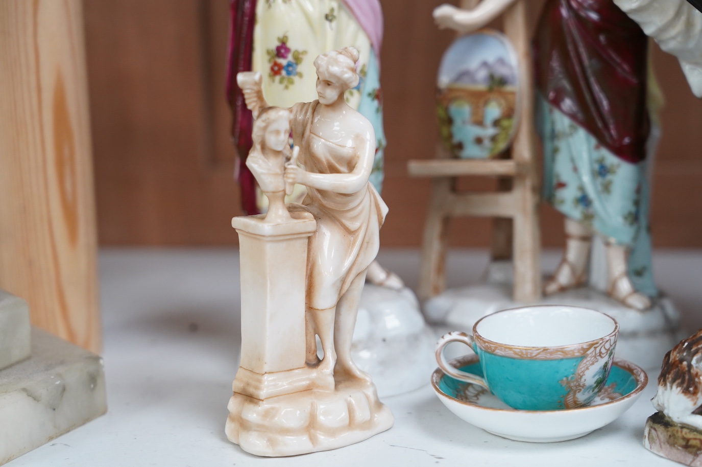 A 19th century French Mansion House Dwarf, a pair of Volkstedt figures, a Meissen dog, cup and saucer and a German porcelain female sculpture, tallest 21cm. Condition - fair to good, a few minor chips